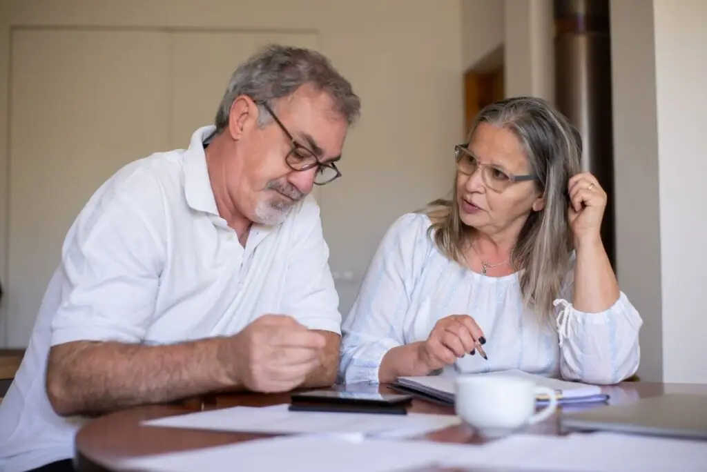 Casal de idosos organizando documentos e finanças em casa
