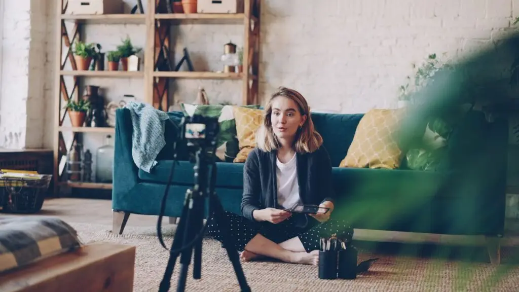 Mulher gravando um vĂdeo para o canal em casa com câmera