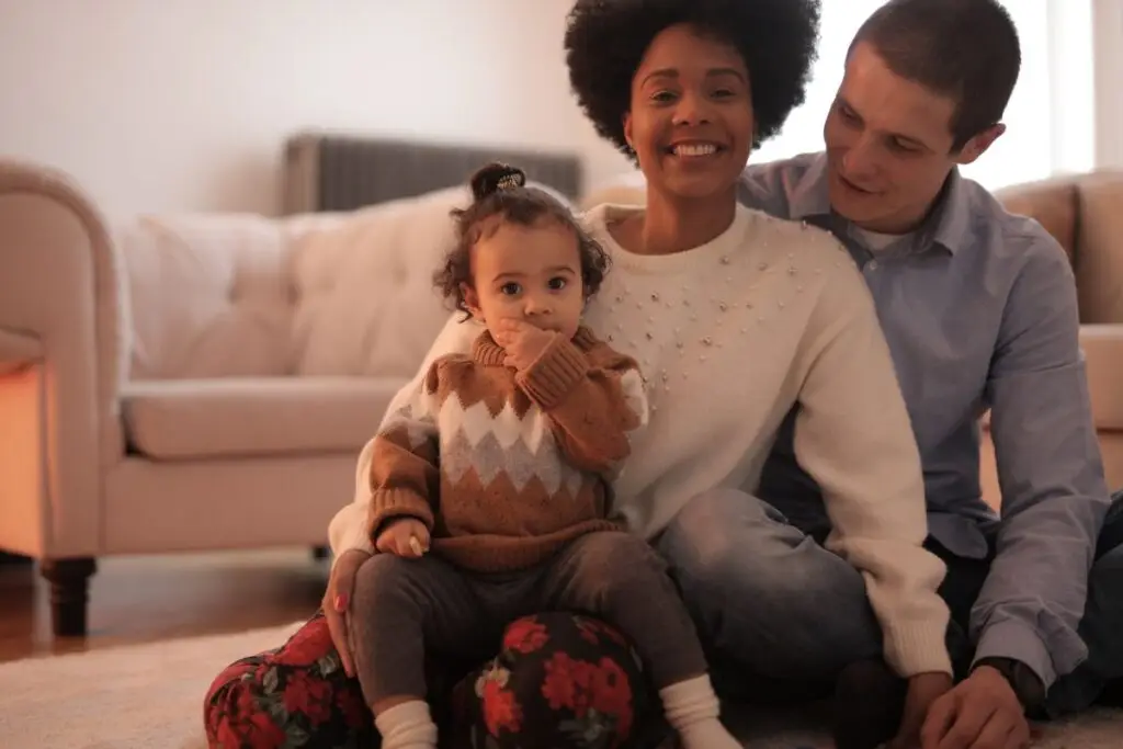 Família com bebê reunida no sofá de casa